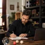 Artiste indépendant préparant le développement de son activité dans son atelier de travail entouré de matériel de spectacle.