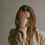 a woman covering her face with her hands