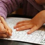 a child is drawing on a piece of paper