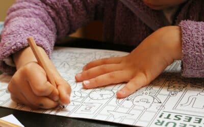 a child is drawing on a piece of paper