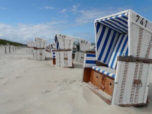 Rangée de cabines de plage rayées bleues et blanches sur plage de sable fin