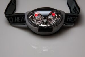 Casque de sécurité avec phares et réflecteurs, bandeau noir, sur fond neutre
