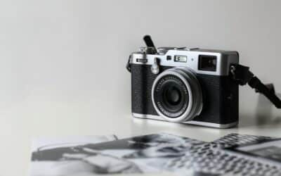 black and gray film camera near printed photos