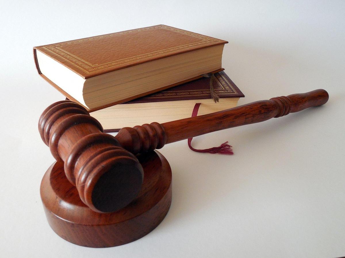 Marteau de justice sur socle, livre ouvert, livre fermé