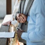 Deux individus signant des papiers lors d'une réunion professionnelle
