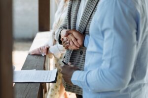 Deux individus signant des papiers lors d'une réunion professionnelle