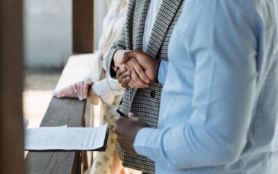 Deux individus signant des papiers lors d'une réunion professionnelle