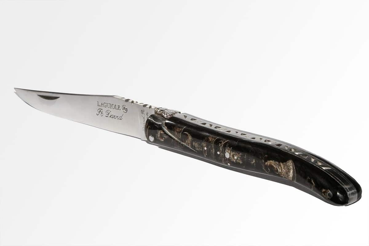 Un couteau de poche ouvert, manche noir, lame brillante, sur fond blanc