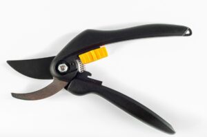 Un secateur de jardinage à main noir avec levier jaune posé