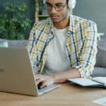 Man wearing headphones working on a laptop at a desk